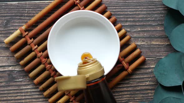 Soy Sauce in a Container with Leaf on White Background