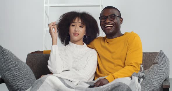 Dissatisfied African American Woman Ethnic Girl Sitting on Couch with Her Smiling Black Man Husband