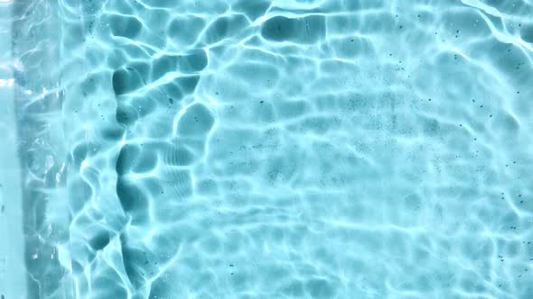 Transparent Blue Colored Clear Water Surface Texture with Ripples Splashes and Bubbles in Sunlight