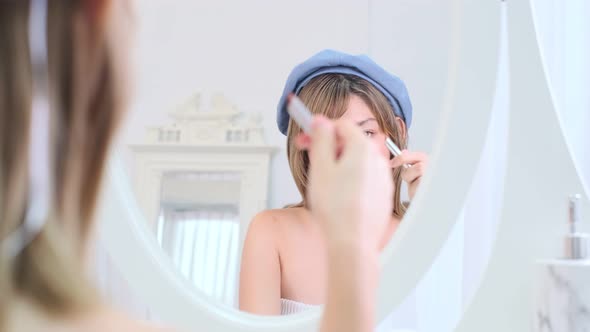 Beautiful young asian woman applying lipstick pink