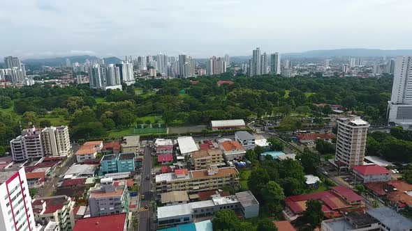 Aerial drone footage contrast between the residential area and the modern buildings behind the park