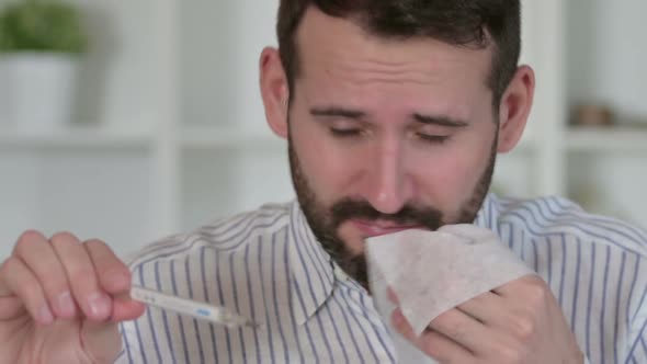 Sick Man Checking Temperature on Thermometer 