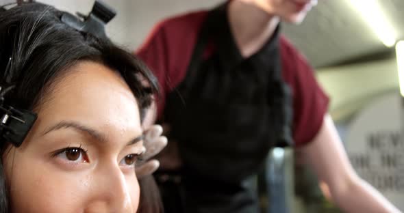 Hairdresser dyeing hair of her client