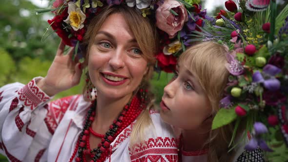 Closeup Portrait of Happy Smiling Ukrainian Mother Talking with Curios Daughter As Child Kissing