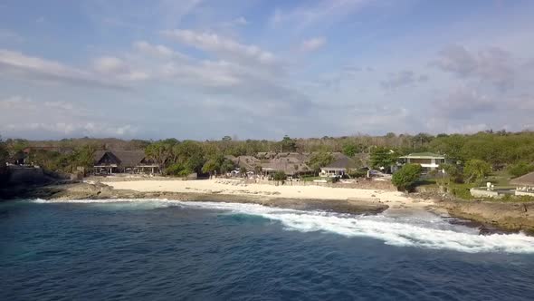 Aerial drone view of a luxury villa on a scenic tropical island in Lembongan IndonesiaBig ocean wav