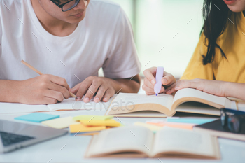 n and man studying for a test or an exam. Tutor books with friends. Young students campus helps friend catching up and learning.
