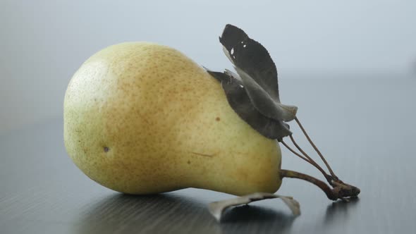 Single fruit from genus Pyrus 4K 2160p UltraHD tilting footage - Yellow organic pear on the table sl