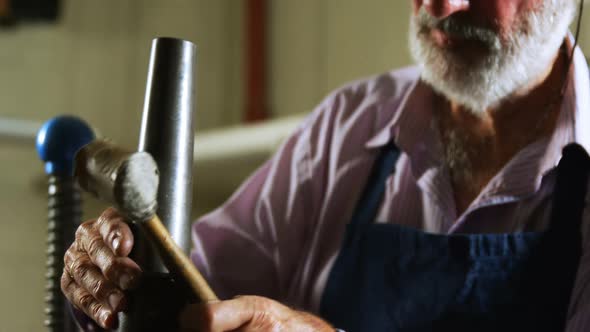 Goldsmith manufacturing jewellery in workshop