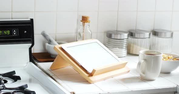 Digital tablet and cup of coffee with breakfast bowl in kitchen 4k