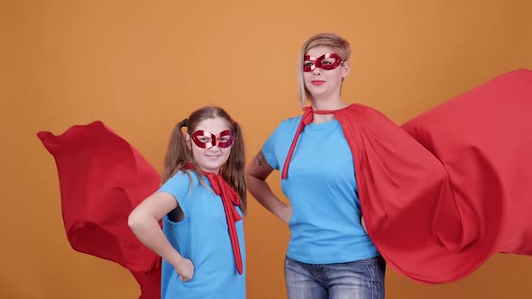 Cute Teen Girl with Her Mom Pretending To Be Superheroes