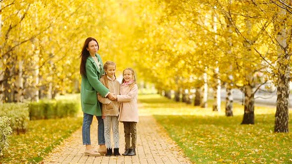 Family of Mother and Kids in Fall. Young Mother and Little Girls Enjoy Warm Autumn