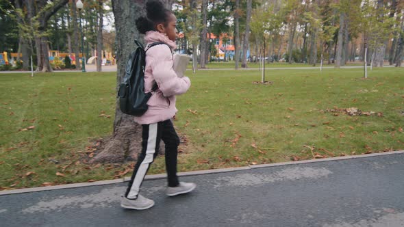 Side View Small Schoolgirl Little Afro American Girl Child African Baby Pupil with Backpack and Book