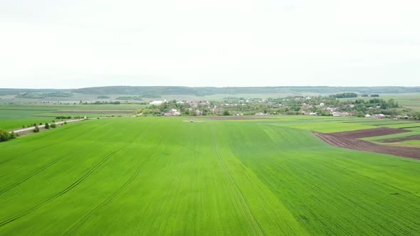 Aerial View of Farming Tractor Spraying on Field with Sprayer Herbicides and Pesticides