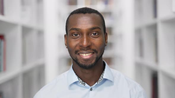 African American Man Portrait Smiling Looking at Camera Standing in Library