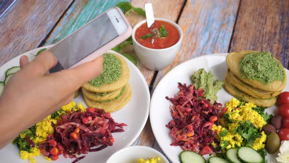 Hands Taking a Picture of Plates with Vegan Breakfast with the Smartphone. Healthy Life Style