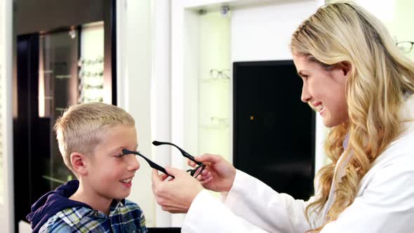 Female optometrist prescribing spectacles to young patient