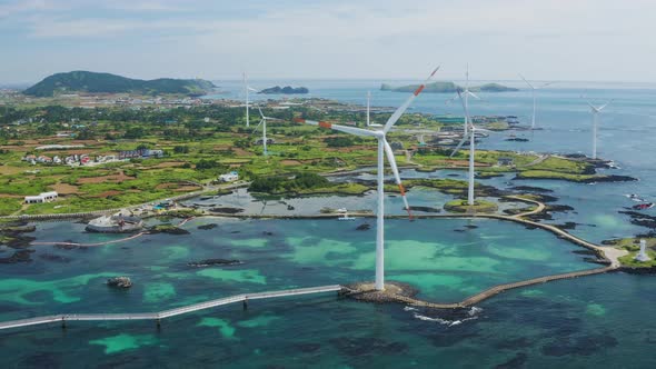 An island village with sea, sky and wind turbines.