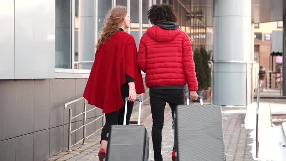 Couple in Red Clothing with Suitcases Going for Flight