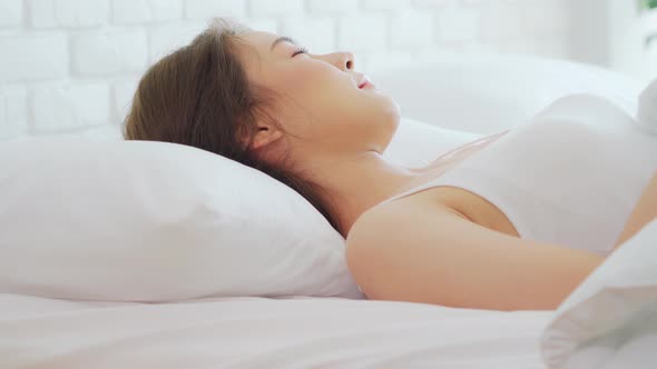 Asian woman wearing Pajamas sleep close her eyes smile sleep and sweet dream