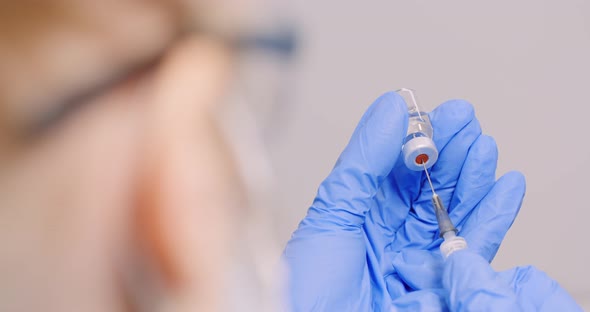 Doctor Filling Syringe with Vaccine, Preparing for Injection. COVID-19