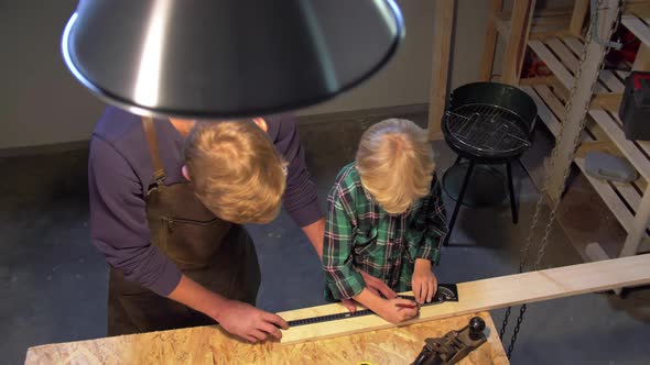 Man and Boy Work with Wood Board in the Workshop, Slow Motion