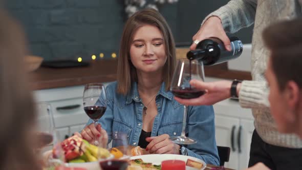 Closeup of a Caucasian Man's Hands Holding Two Glasses Pouring Red Wine Into Them