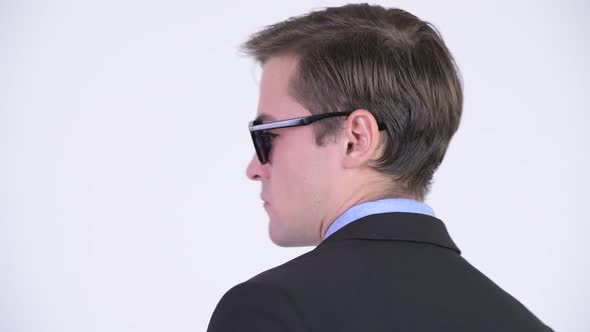 Rear View of Young Handsome Businessman Wearing Sunglasses and Looking Back