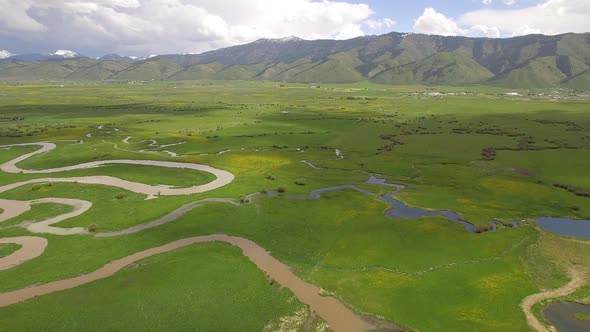 Aerial view flying backwards over winding river system