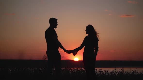 Silhouettes of Young Couple at Sunset