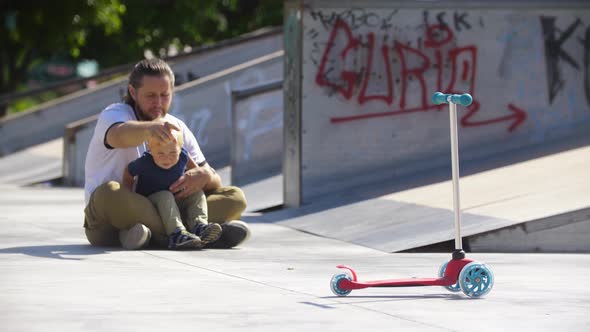 Little Boy and His Father at the Skate Park