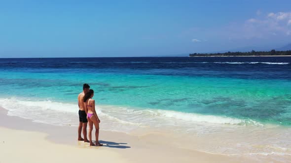 Two people tanning on exotic tourist beach time by transparent water with white sand background of G