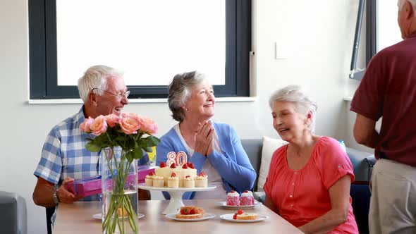 Senior woman receiving gift from her friend