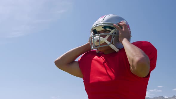 American football player putting on his helmet