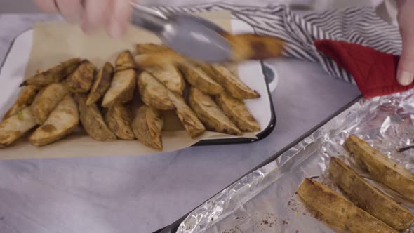 Time lapse. Freshly baked potato wedges with spices on a white serving tray.