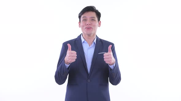 Happy Young Asian Businessman Giving Thumbs Up and Looking Excited