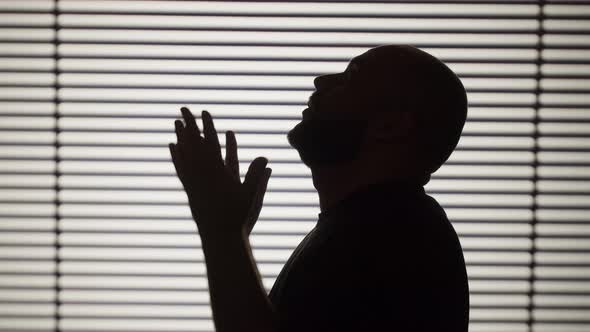 Shadow of Crying Man Closeup Silhouette of Depressed Male Person on White Striped Background