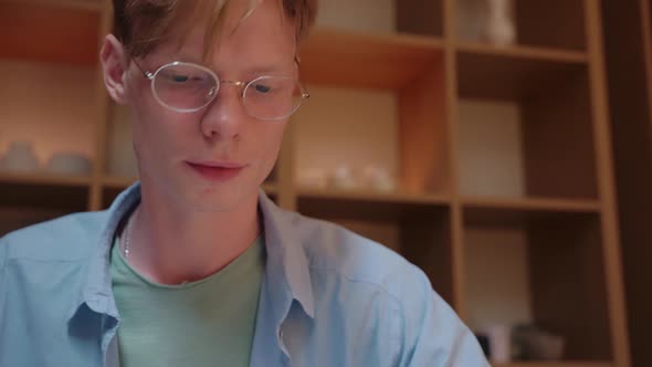 Closeup Shot of Young Man in Glasses Studying Writing Notes and Reading