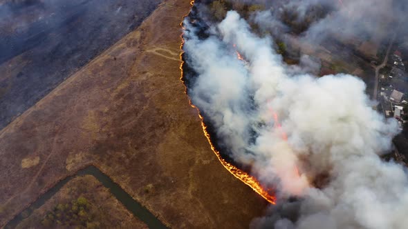 Forest and field fire. Dry grass burns, natural disaster. Aerial view of Wildfire on the Field