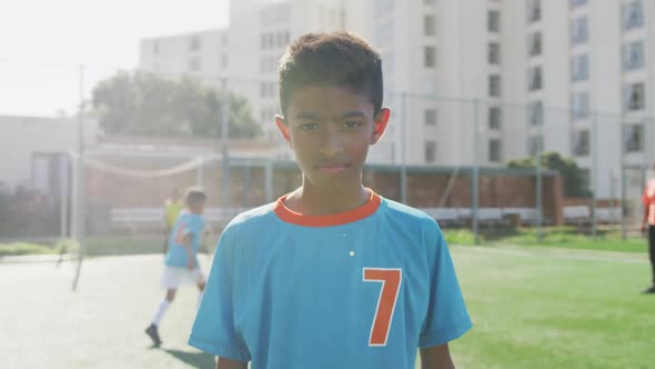 African American soccer kid in blue smiling and looking at camera