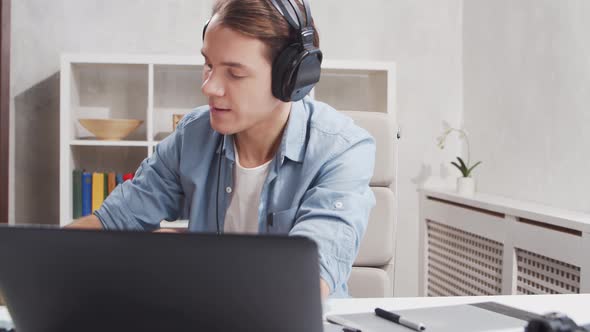 Workplace of freelance worker at home office. Young man works using computer.