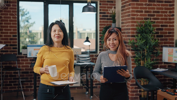les, getting ready to work on business growth and development. Asian women talking about creative partnership in startup office.