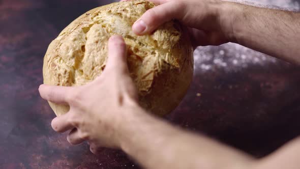 Close Up on Hands Cracking Open Fresh Baked Bread