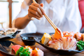 Young asian woman eating sashimi set in japanese restaurant - PhotoDune Item for Sale