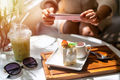 Young woman taking photo of dessert with smart phone for social media in restaurant while traveling - PhotoDune Item for Sale