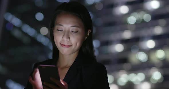 Businesswoman use of smart phone in city at night 