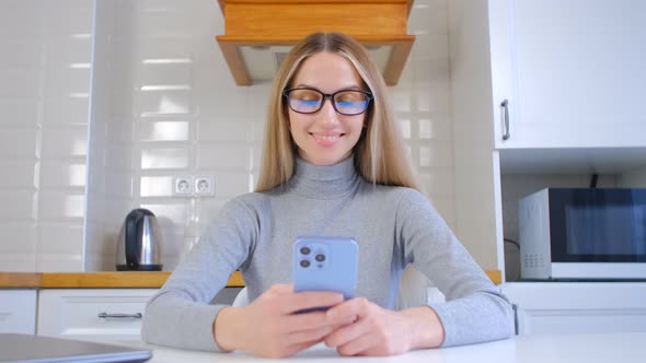 Cheerful blonde female using modern smartphone for communication on social media app in 4k video