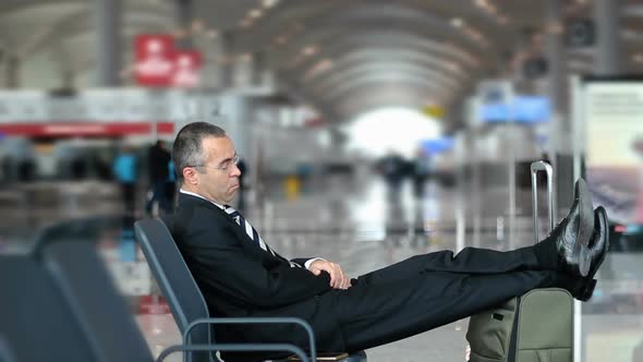 Business man sleeping in the airport, waiting for flight