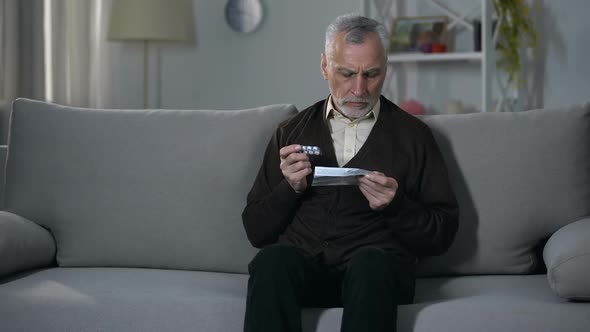 Old Man Reading Leaflet With Instructions for Medication, Risky Self-Treatment