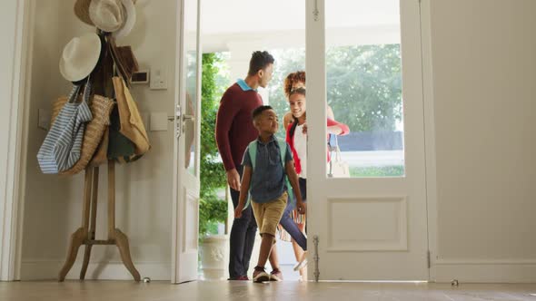 Happy african american family entering the house from front door