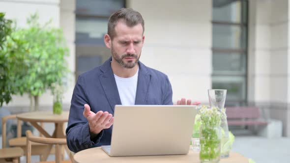 Man Reacting to Loss While Using Laptop Outdoor